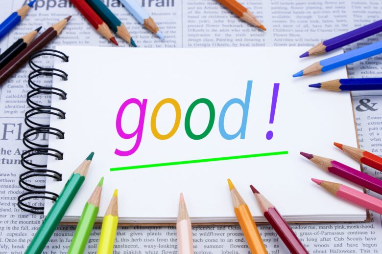 「good」と書かれたノートを囲む色鉛筆