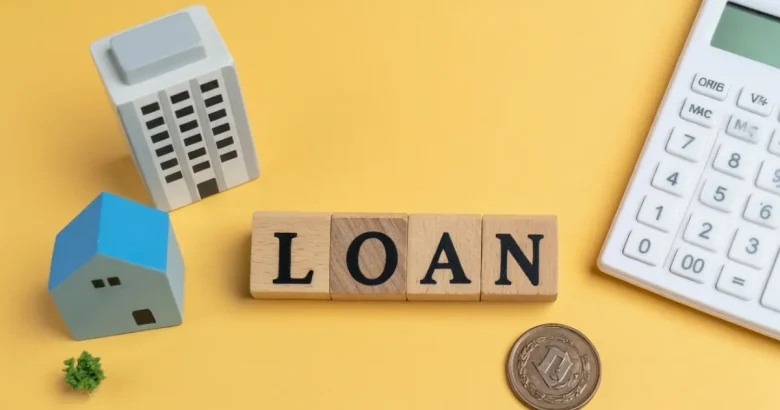 マンションや家の模型、電卓、おもちゃのコイン、「ローン」とかかれたブロックが置かれている