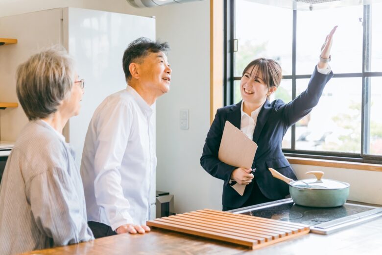 室内で女性の案内を受けるシニア夫婦