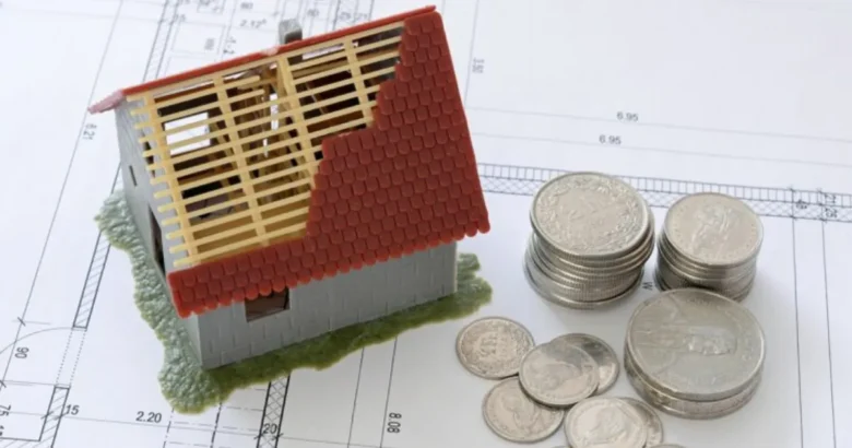 家の模型と積み上げられた硬貨