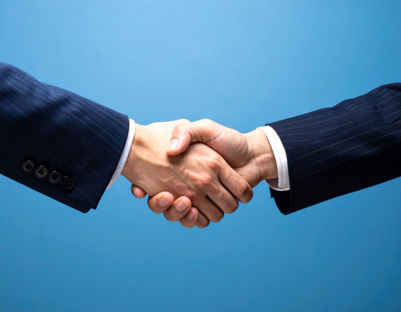 スーツを着た人が握手をしている手元
