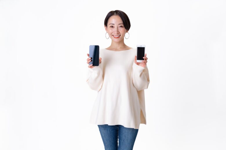 両手にスマートフォンを持つ女性