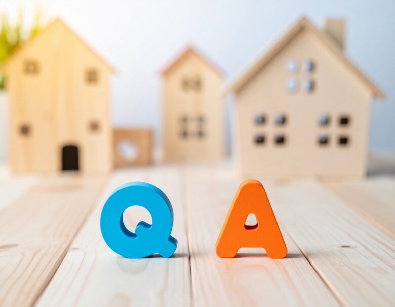 QとAの文字。背景に家の置物が置いてある。