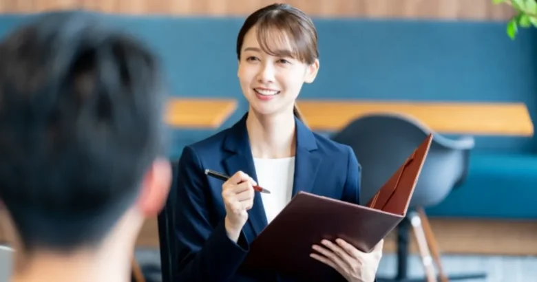 ファイルを手に説明するスーツを着た女性