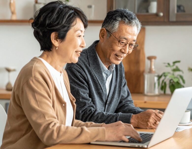 一緒にパソコンを見ている夫婦