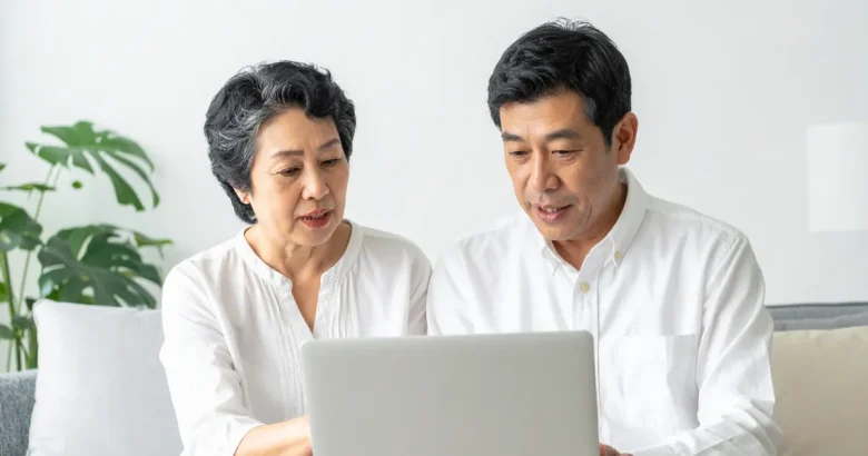 パソコンで調べている夫婦