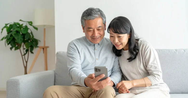 一緒に携帯電話を見て話し合っている夫婦